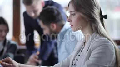 一个年轻漂亮的女孩正在她的笔记本电脑上寻找<strong>一些</strong>东西，然后在她的平板电脑上做<strong>一些</strong>笔记。